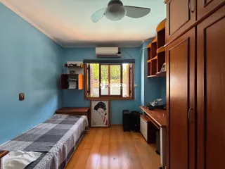 Quarto com piso de madeira e paredes azul claro em uma residência.