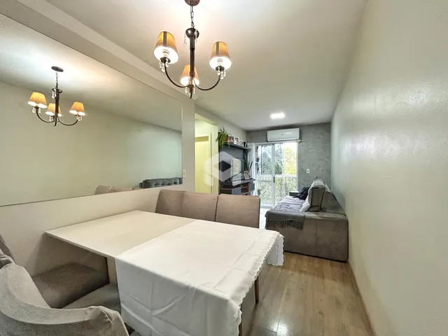 Sala de estar com mesa de jantar e espelho em um imóvel no Brasil.