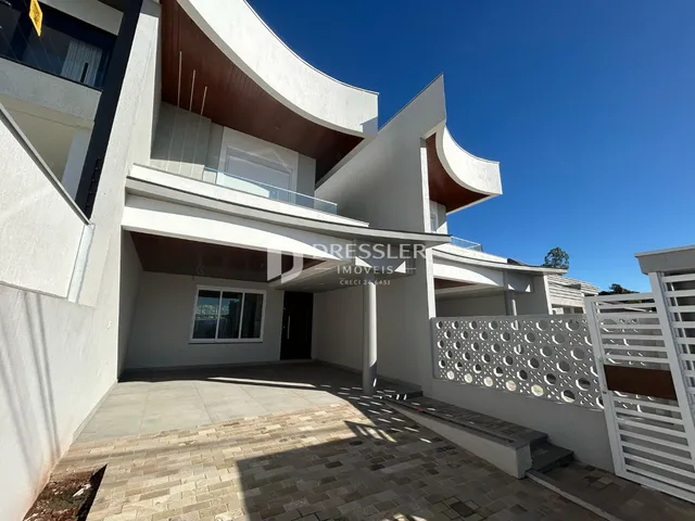 Fachada moderna de uma residência em Lajeado, Brasil, com área externa pavimentada.
