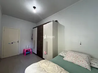 Quarto com cama e armário em ambiente claro.
