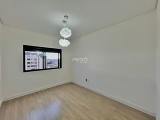 Sala de estar com piso de madeira e grande janela.