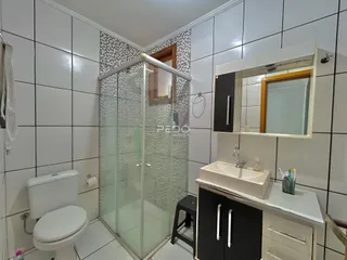 Banheiro com box de vidro e louças brancas em um imóvel no Brasil.
