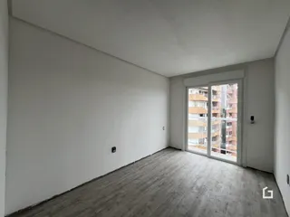 Ambiente interno de uma sala com piso de madeira e porta de vidro.