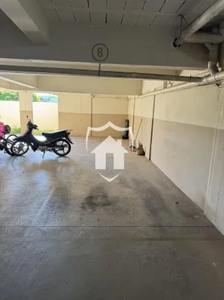 Uma área aberta com piso de concreto e uma motocicleta estacionada.