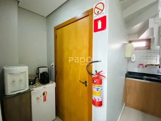 Hall de entrada com porta de madeira e extintor de incêndio em uma residência.