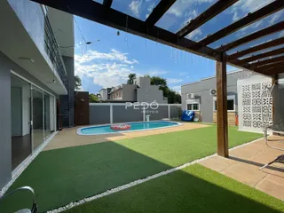 Vista de uma área externa com piscina e gramado de uma residência em Lajeado.