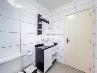 Banheiro com revestimento branco e bancada escura.