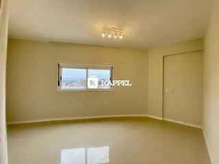 Foto interna de um cômodo amplo com paredes claras e piso de cerâmica.