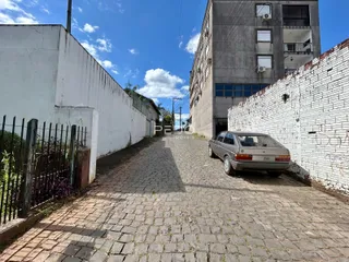 Vista de um beco pavimentado entre duas paredes de edifícios residenciais.