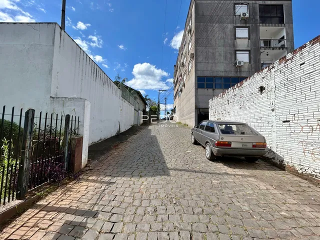 Vista de um beco pavimentado entre duas paredes de edifícios residenciais.