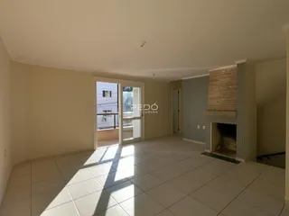 Ambiente interno de uma sala com piso de cerâmica e lareira.