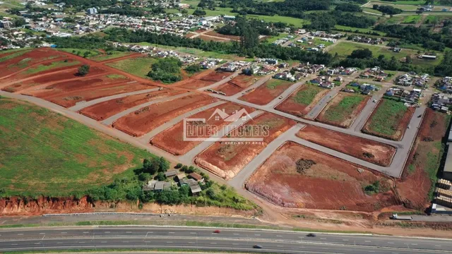 Vista aérea de uma área de terra com vegetação e infraestrutura de estrada.