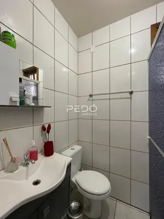 Foto de um banheiro com azulejos brancos e louças sanitárias.