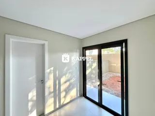 Hall de entrada com porta branca e porta de vidro que dá acesso ao quintal.
