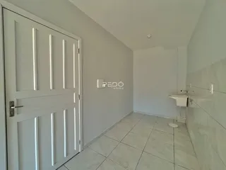 Hall de entrada com porta branca e piso de cerâmica em um imóvel no Brasil.