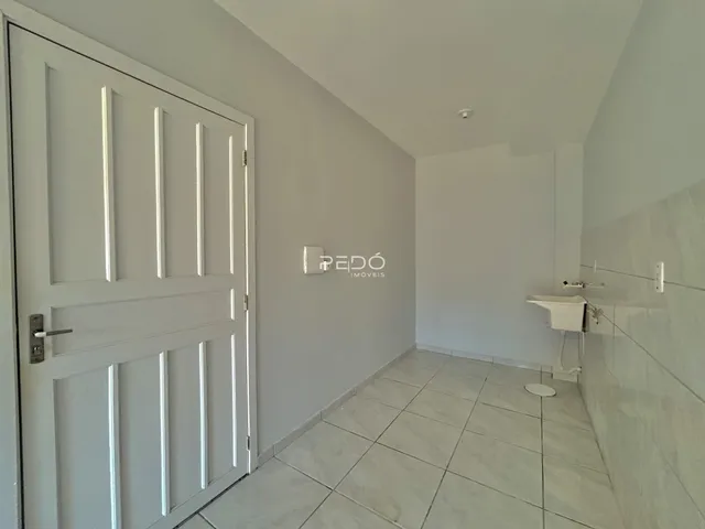 Hall de entrada com porta branca e piso de cerâmica em um imóvel no Brasil.