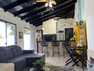 Sala de estar com sofá e mesa de jantar em um imóvel no Brasil.