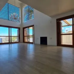 Sala ampla com piso de madeira e grandes janelas em um imóvel em Lajeado.