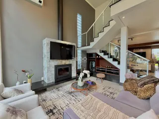 Sala de estar moderna com lareira e escadaria em um imóvel em Lajeado.