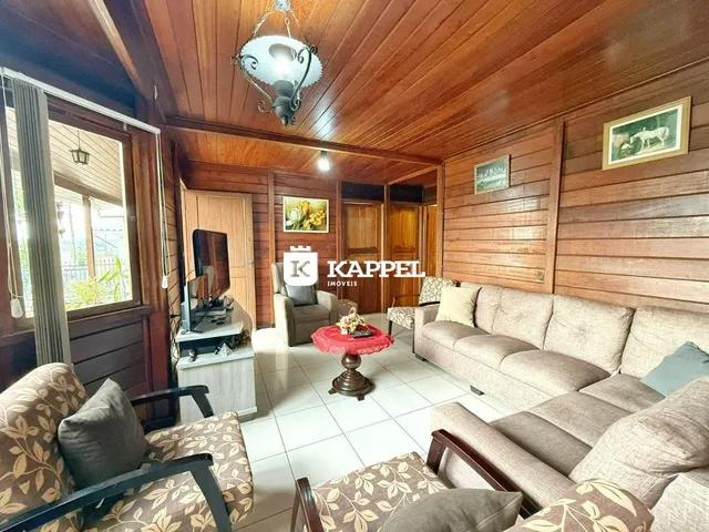 Sala de estar com paredes de madeira e sofá de três lugares.