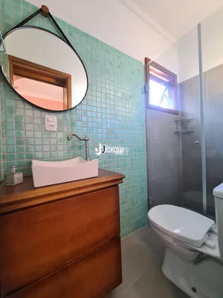 Foto de um banheiro com azulejos turquesa e bancada de madeira.