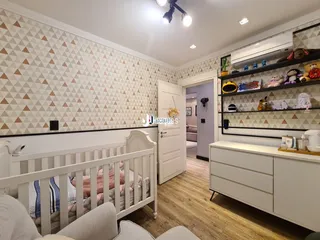 Quarto com cabeceira e estante em um apartamento no Brasil.