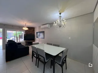 Sala de estar com mesa de jantar e lareira em um apartamento.