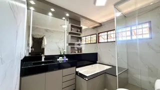 Banho com revestimento de mármore e espelho no interior de uma residência.