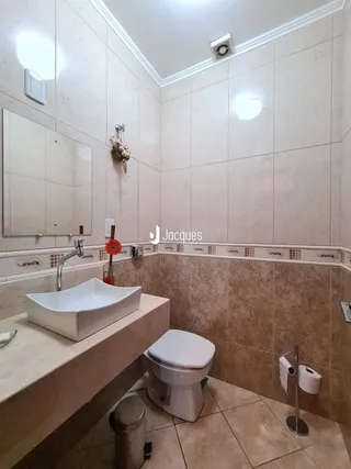 Foto de um banheiro com azulejos brancos e louças sanitárias.