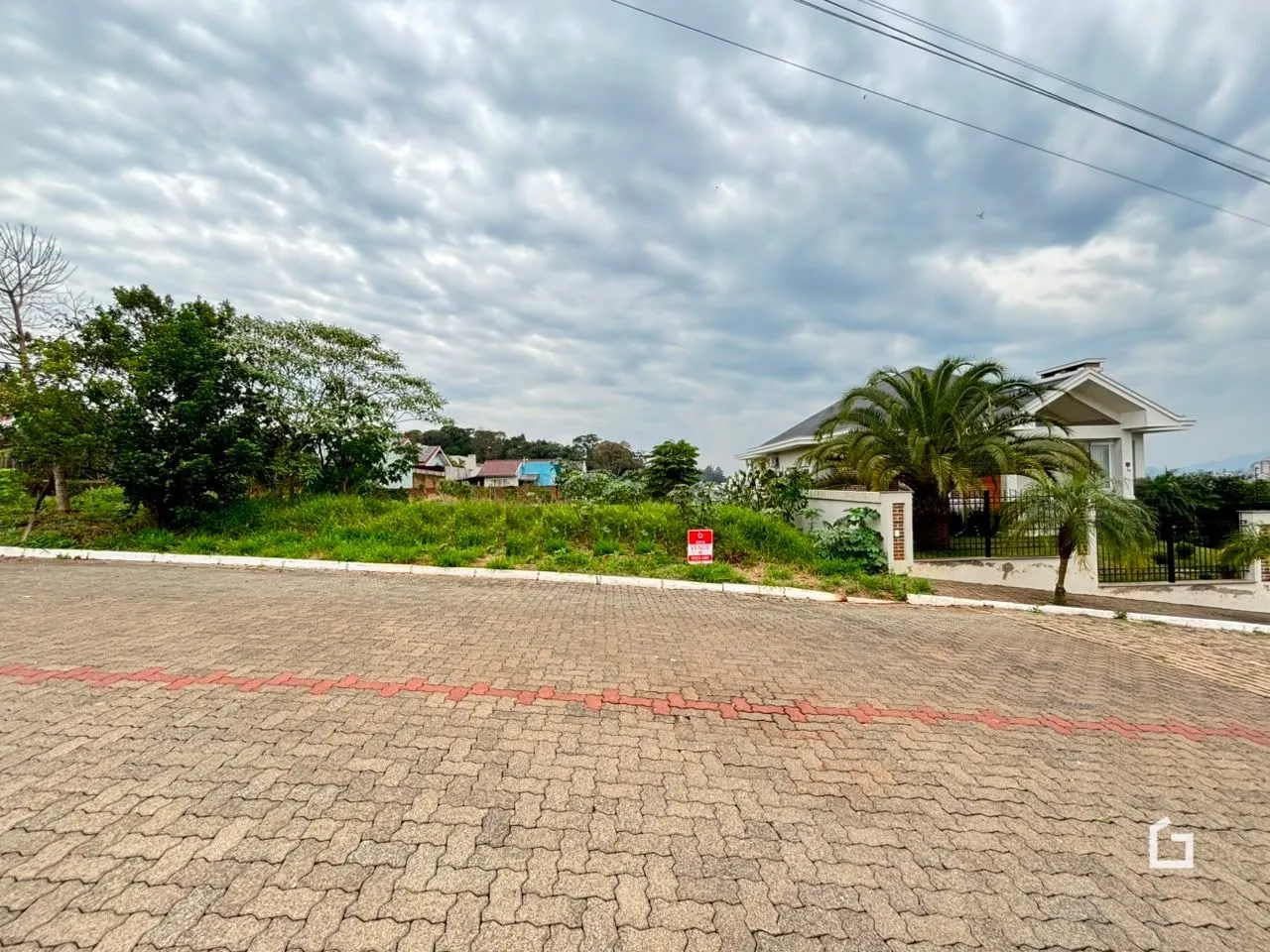 Vista externa de uma residência em Lajeado, Brasil, com paisagem verde e área pavimentada.