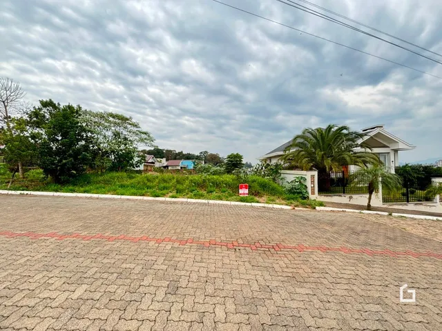 Vista externa de uma residência em Lajeado, Brasil, com paisagem verde e área pavimentada.