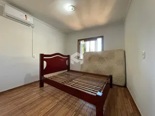 Foto de um quarto com cama de madeira e piso de madeira.
