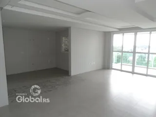 Ambiente interno de uma sala ampla com piso claro e paredes brancas.