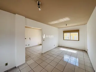 Interior de uma sala com piso de cerâmica e paredes brancas.