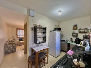 Vista interna de uma cozinha e sala de estar em um imóvel no Brasil.