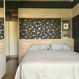 Foto de um quarto com cama e cabeceira em um imóvel.