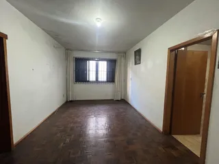Sala de estar com piso de madeira e janela em um imóvel.