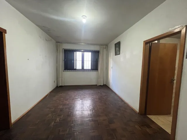 Sala de estar com piso de madeira e janela em um imóvel.