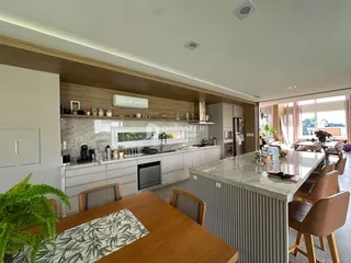 Vista da cozinha moderna com ilha e área de jantar em Lajeado.