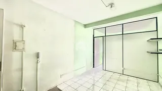 Hall de entrada com piso de cerâmica e portas de vidro.
