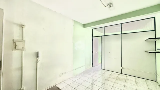 Hall de entrada com piso de cerâmica e portas de vidro.