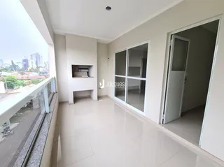 Vista da sala com grande janela para a paisagem urbana.