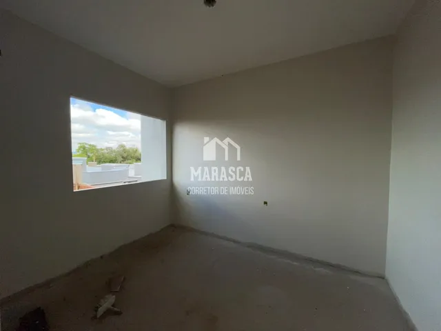 Foto de um cômodo interno com parede lisa e piso em obra.