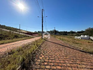 Uma estrada de tijolos leva a uma área rural sob um céu azul.