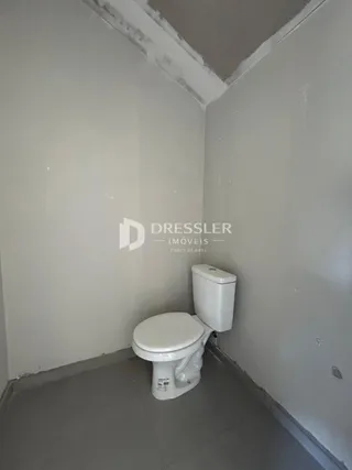 Foto de um banheiro interno com paredes brancas.