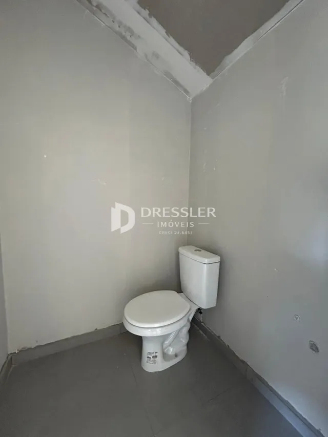 Foto de um banheiro interno com paredes brancas.