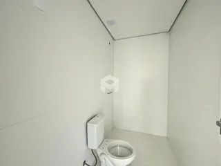 Foto de um banheiro interno com paredes brancas e piso claro.