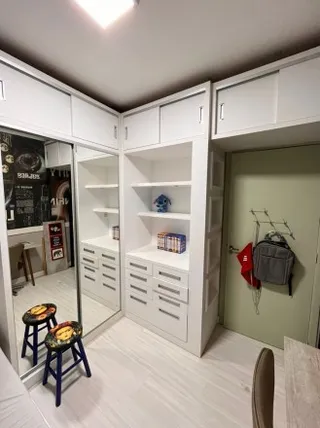 Prateleiras brancas de armário em um ambiente interno de uma residência.