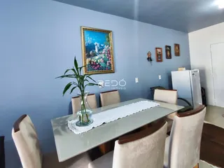 Ambiente interno de uma sala de jantar com paredes azul e decoração de parede.