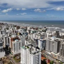 Vista aérea de uma área urbana costeira com edifícios densos.
